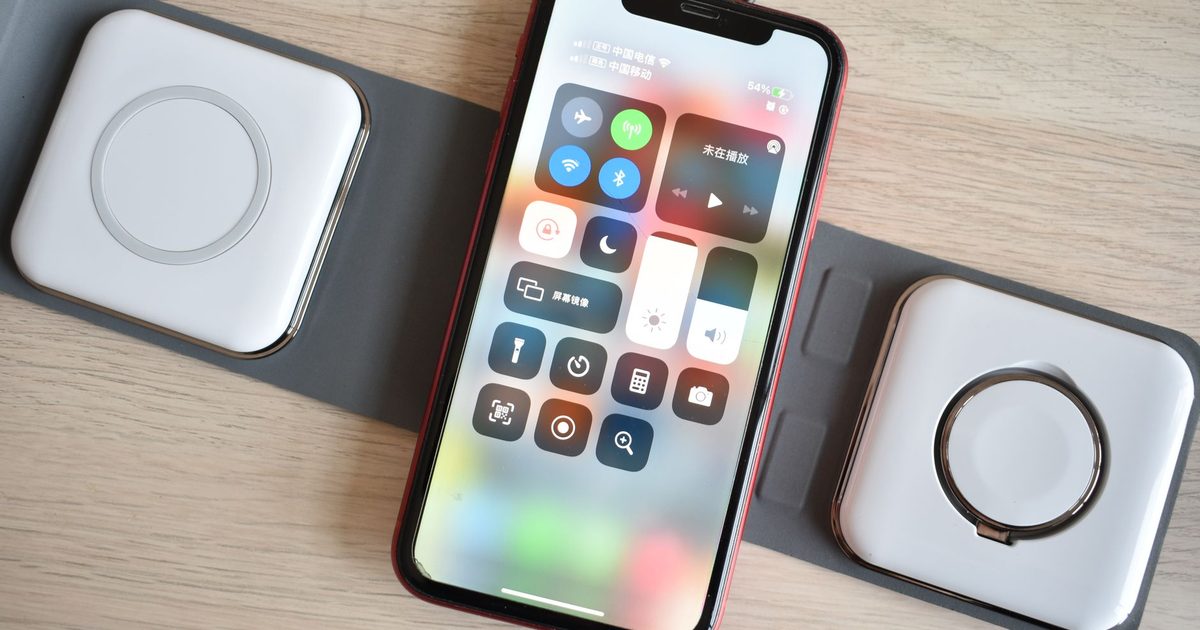 a foldable three-pad wireless charging station with a phone charging on the centre pad