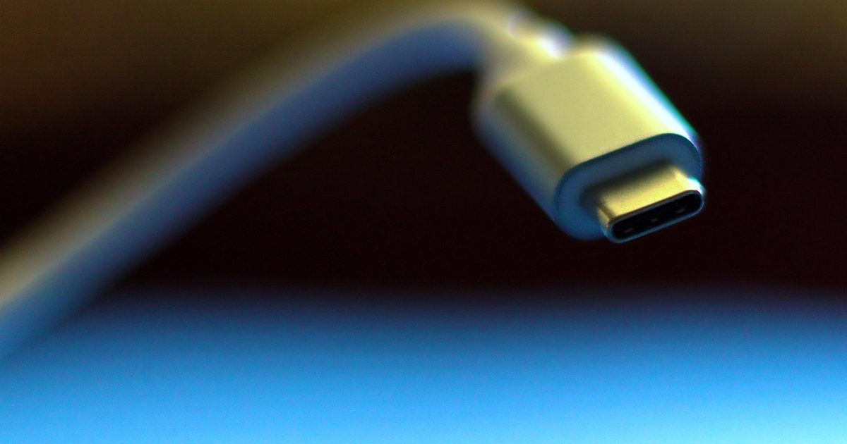 a usb-c cable connector with the cable curving away on a blue lit surface